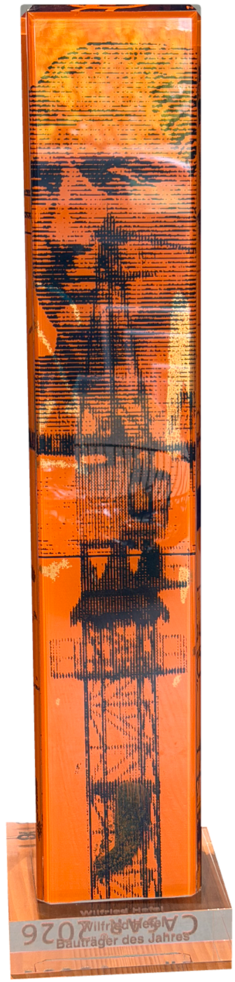 Der Cäsar® 2026 Pokal: orangefarbene Glassäule mit Druck auf einem transparenten Sockel mit der Gravur Wilfried Hefel
