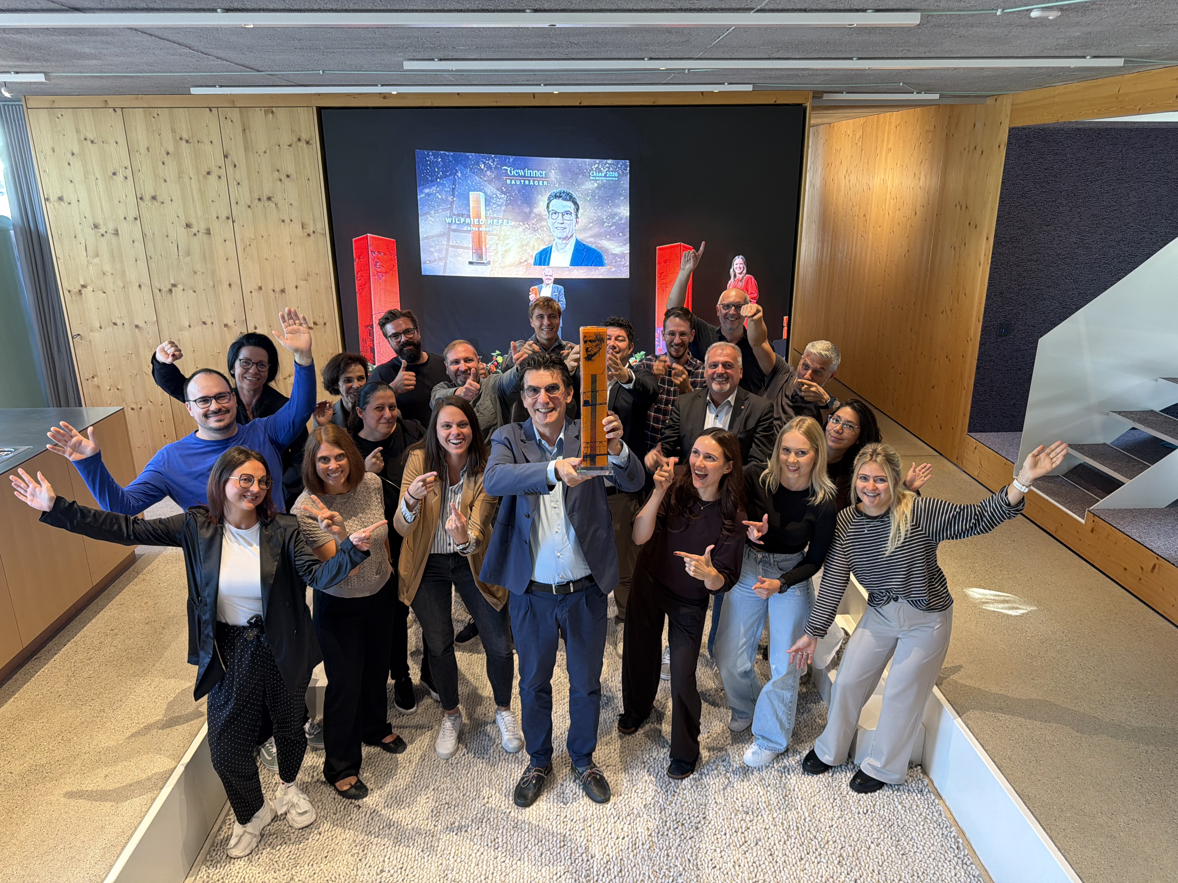 Das RIVA home Team jubelt gemeinsam mit Wilfried Hefel, der den CÄSAR® Immobilienaward 2026 in die Höhe hält